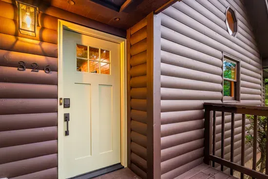 Warm cabin entry with covered porch and inviting front door