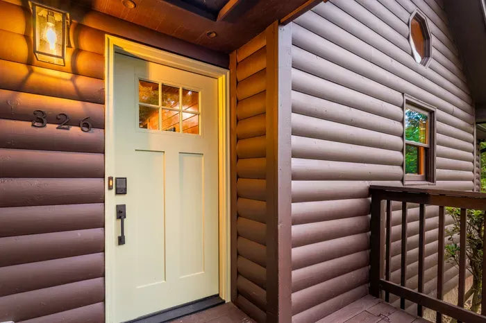 Warm cabin entry with covered porch and inviting front door