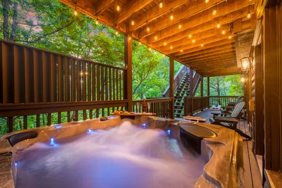 Private covered hot tub deck with string lights and peaceful forest views