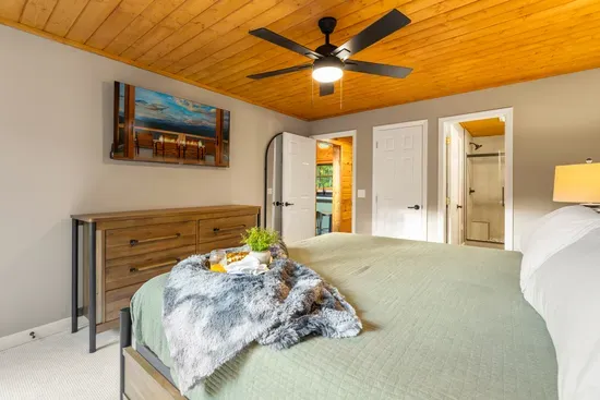 Cozy bedroom retreat with wood ceiling and private bath