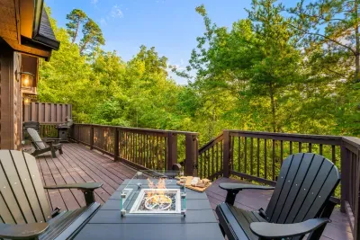 Private wooded deck with fire table, grill, and serene outdoor seating
