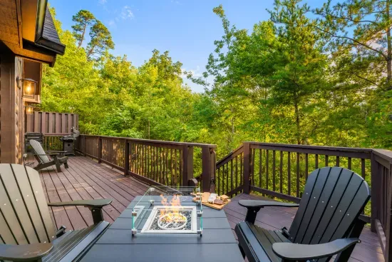 Private wooded deck with fire table, grill, and serene outdoor seating