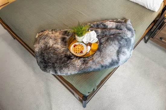 Cozy bed styling with breakfast tray for a warm, boutique-style stay