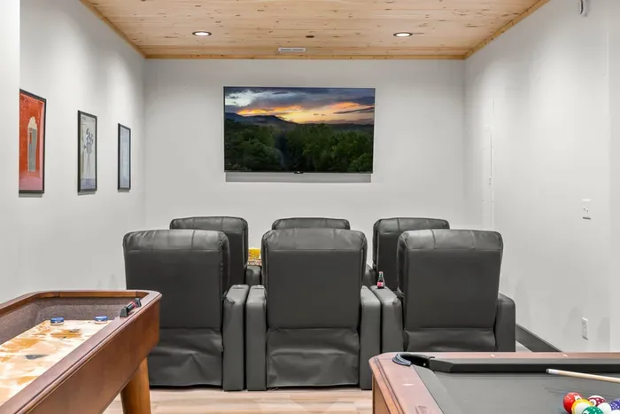 Theater room with comfortable seating and a large screen for movie nights.