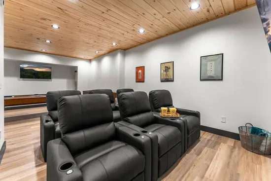 Theater room with comfortable seating and a large screen for movie nights.
