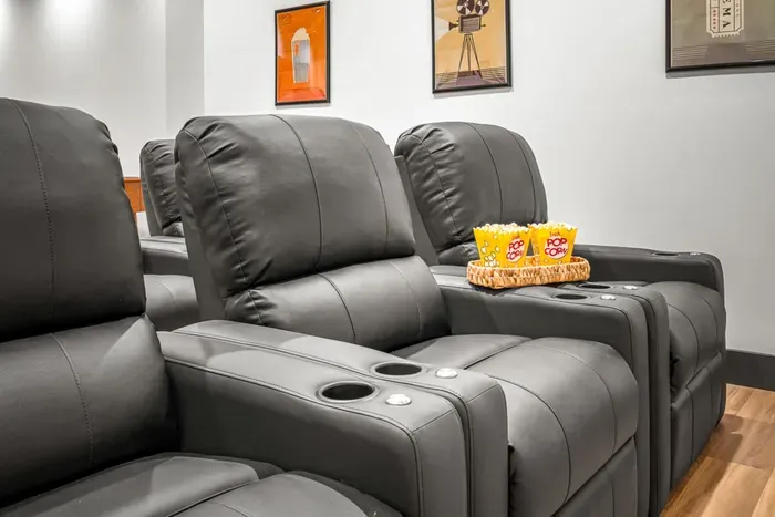 Theater room with comfortable seating and a large screen for movie nights.