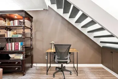 Cozy under-stair workspace with desk, storage, and classic charm