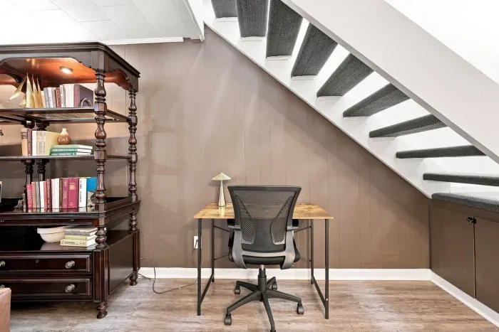 Cozy under-stair workspace with desk, storage, and classic charm