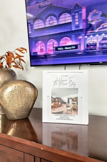 Stylish console setup with Roku TV and a thoughtful guest welcome guide