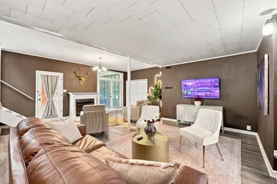 Spacious stylish living room with fireplace, TV, and cozy seating