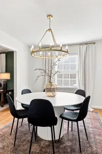 Bright dining room with designer chandelier and seating for six
