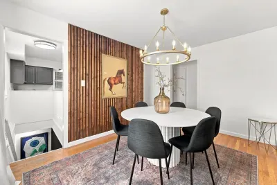 Stylish dining room with wood accent wall, chandelier, and seating for six