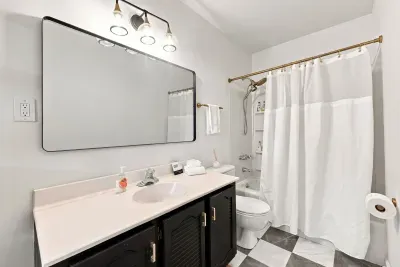 Bright, updated bathroom with large mirror and tub-shower combo