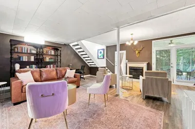 Cozy designer living room with fireplace, bookshelves, and patio access