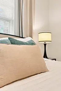 Bright, cozy bedroom with plush bedding and warm bedside lighting