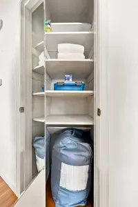 Well-stocked linen closet with extra towels, bedding, and handy storage