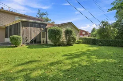 Spacious private backyard with lush lawn and screened-in patio