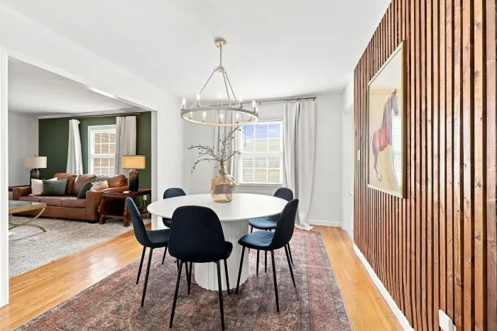 Bright dining room with designer lighting and warm wood accent wall