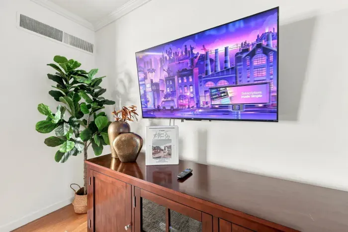 Large wall-mounted TV with stylish console and modern decor