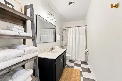 Bright full bath with stocked towel shelves and stylish modern finishes