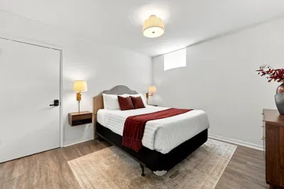 Cozy modern bedroom with plush bedding, warm lighting, and stylish accents