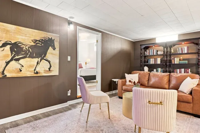 Cozy lounge with leather sofa, bookshelves, and stylish bonus seating