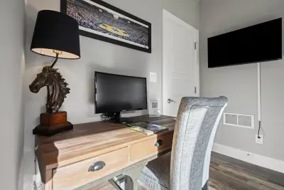 First floor entryway offers a pull-out queen sofa bed, smart tv, and dedicated workspace including an external computer monitor for your convenience, including a half bath.