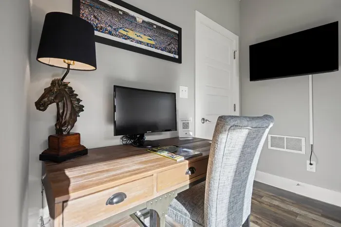 First floor entryway offers a pull-out queen sofa bed, smart tv, and dedicated workspace including an external computer monitor for your convenience, including a half bath.