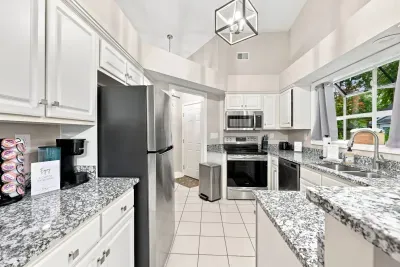 Bright vaulted kitchen with granite counters and stainless appliances