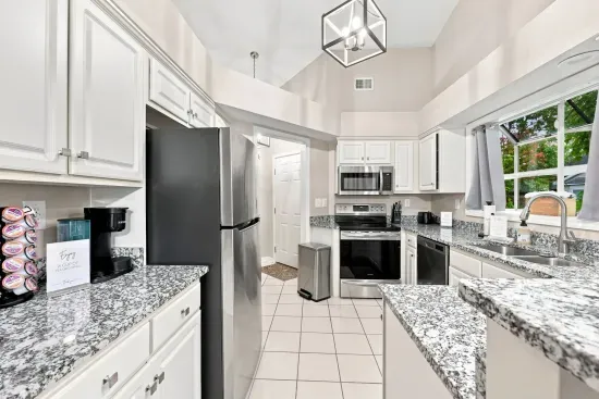 Bright vaulted kitchen with granite counters and stainless appliances