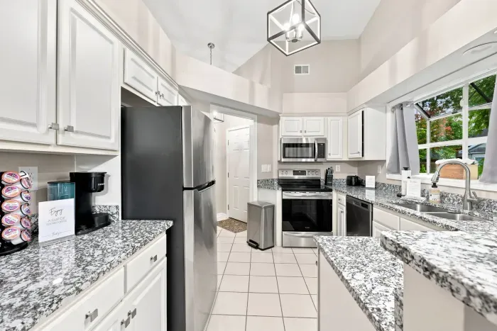 Bright vaulted kitchen with granite counters and stainless appliances