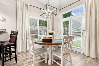 Bright dining nook with yard views, natural light, and stylish seating for four