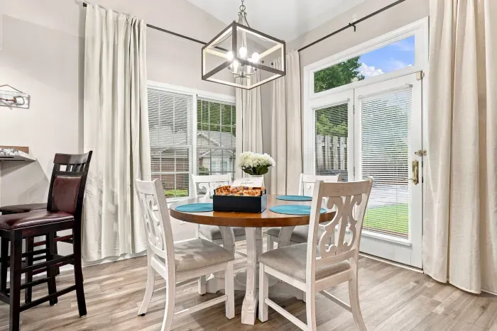 Bright dining nook with yard views, natural light, and stylish seating for four