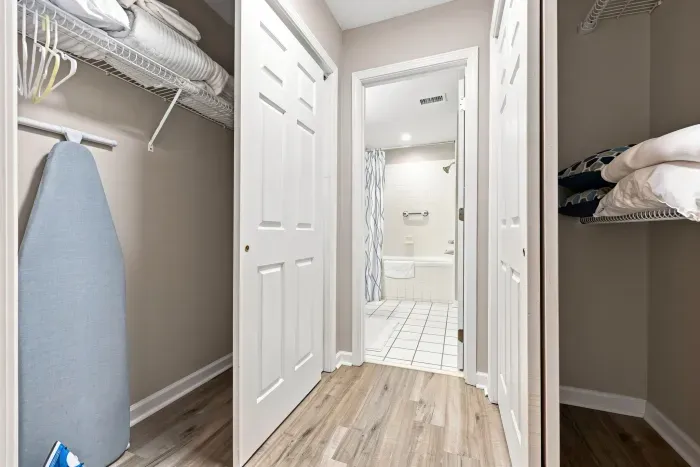 Ample closet storage with linens, ironing board, and easy bathroom access