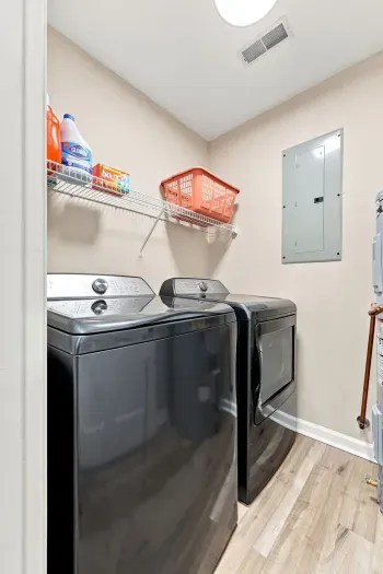 Convenient in-home laundry room with full-size washer, dryer, and storage