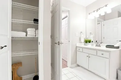Bright bathroom with large vanity, great lighting, and extra linen storage
