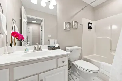 Bright, spotless bathroom with full tub-shower and spacious vanity