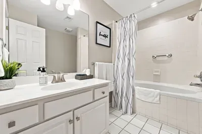 Bright full bathroom with spacious vanity and tub/shower combo