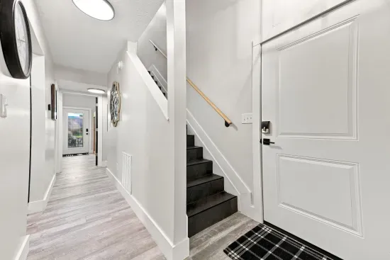 Bright modern entryway with sleek staircase and airy hallway