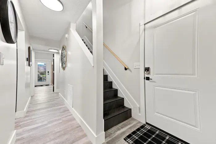 Bright modern entryway with sleek staircase and airy hallway