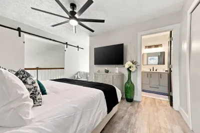 Bright modern bedroom with ensuite bath, TV, and stylish finishes