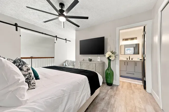 Bright modern bedroom with ensuite bath, TV, and stylish finishes