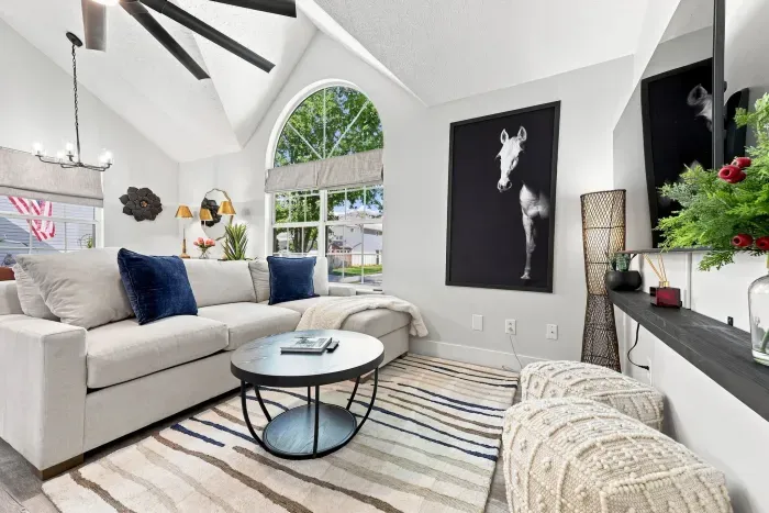 Bright vaulted living room with arched window and stylish modern decor