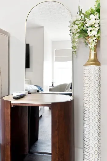 Elegant vanity nook with arched mirror and bright, airy style