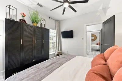 Bright modern bedroom with large wardrobe, TV, and airy natural light