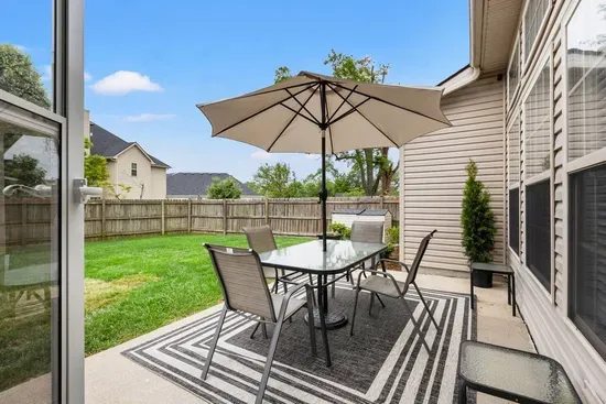 Patio table and chairs equipped for 8 guests, BBQ grill and fenced in backyard