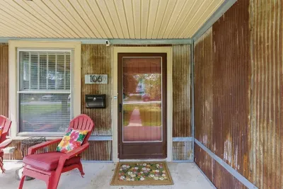 Charming covered porch with cozy seating and rustic curb appeal