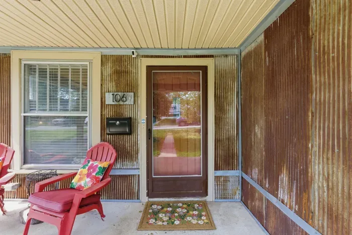Charming covered porch with cozy seating and rustic curb appeal