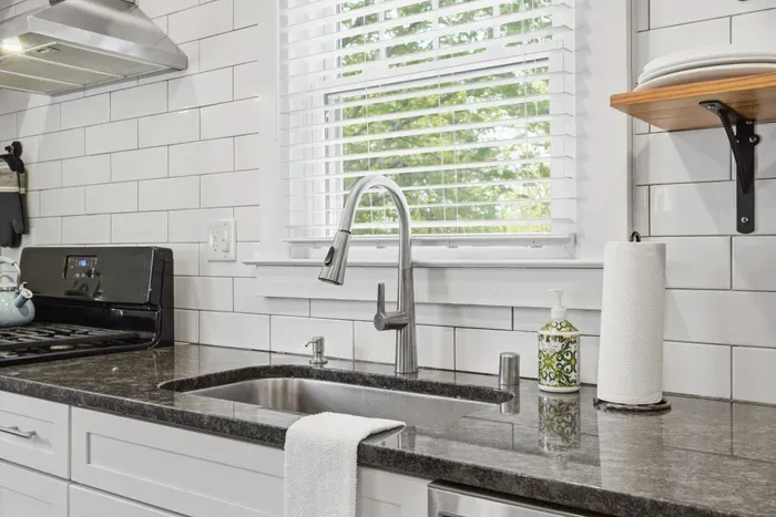 Bright modern kitchen with sunny window, sleek finishes, and stylish design