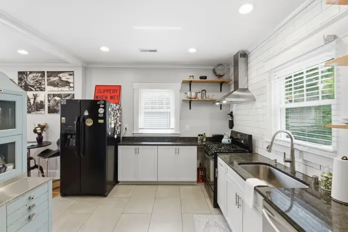 Bright modern kitchen with granite counters, gas range, and sunny windows